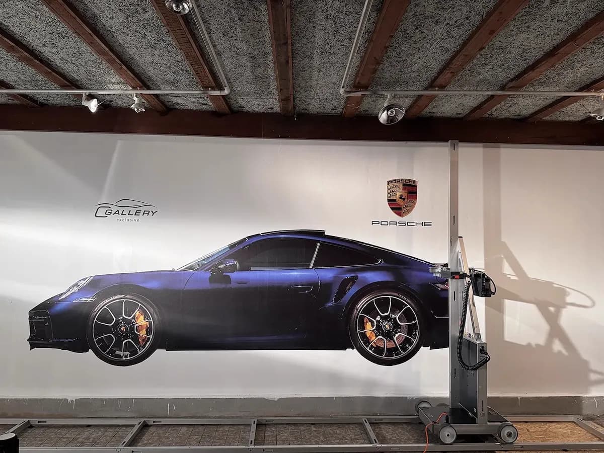 Porsche dealership wall printing with sports car and brand logo by InnoPrint KSA